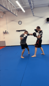 Tom showing some skills as he demonstrates a proper hook punch in Muay Thai class